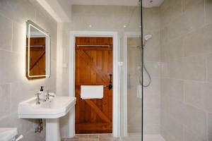 ein Bad mit einem Waschbecken und einer Glastür in der Unterkunft Thatchers Cottage - Rudge Farm Cottages in Bridport + 47 Fotos