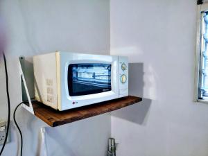 a microwave sitting on a shelf on a wall at A&C Temporarios in Corrientes