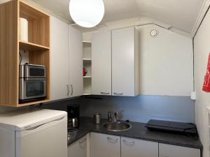 a small kitchen with white cabinets and a sink at Hinkula - Kukonkarinkatu 11 in Rauma