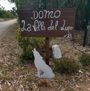 a sign with a dog standing next to a road at Villa del Lupo in Santa Maria la Palma