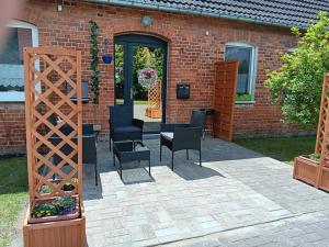 a patio with chairs and a table and a building at NEU! Ferienwohnung Schwalbe in Grünow