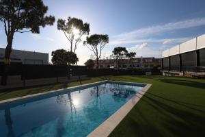 a swimming pool in front of a building with trees at Albufeira Lounge Hotel in Albufeira