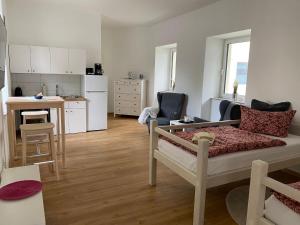 a living room with a bed and a kitchen at FEWO Tribseerdamm in Stralsund