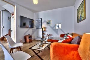 un soggiorno con un divano e un tavolo di LocaLise - M37 - Maison de vacances à deux pas du centre et des plages - wifi inclus - draps inclus - animaux bienvenus - extérieur clos - parking privatif a Le Guilvinec