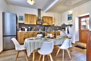 una cucina con tavolo, sedie e frigorifero di LocaLise - M37 - Maison de vacances à deux pas du centre et des plages - wifi inclus - draps inclus - animaux bienvenus - extérieur clos - parking privatif a Le Guilvinec