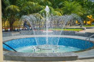 a fountain in a pool with people playing in it at Shri Lawn Park in Sīrkāzhi