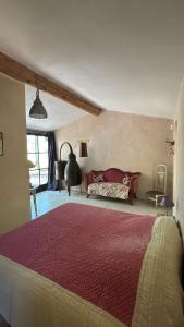 une chambre avec un grand lit et un canapé dans l'établissement La Bastide des Chênes Lacoste, à Lacoste