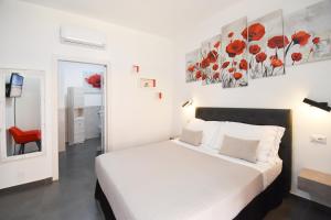 a bedroom with a white bed and a red chair at Elis b&b Villasimius in Villasimius