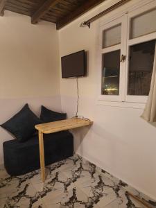 ein Wohnzimmer mit einer Couch und einem Fernseher an der Wand in der Unterkunft Studios in lighthouse in Dahab