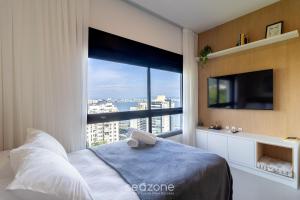 a bedroom with a large window with a view at Estadia tranquila e completa em prédio com piscina – VPD in Florianópolis +44 photos