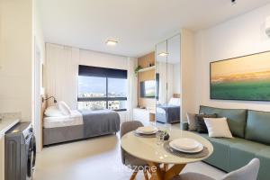 a living room with a bed and a table and a couch at Estadia tranquila e completa em prédio com piscina – VPD in Florianópolis