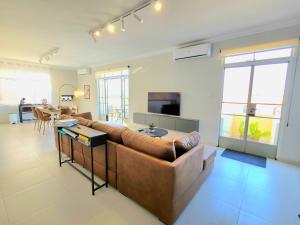 a living room with a brown couch and a table at Marina View in Taʼ Xbiex