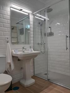 a white bathroom with a sink and a shower at Apartamento El Lago Dos, Cartagena Centro in Cartagena +35 photos