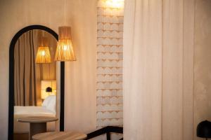 a bedroom with a bed and a mirror and a table at Cala Ponte, a Tribute Portfolio Hotel in Polignano a Mare