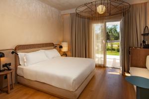 a bedroom with a bed and a large window at Cala Ponte, a Tribute Portfolio Hotel in Polignano a Mare