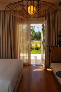 a bedroom with a bed and a sliding glass door at Cala Ponte, a Tribute Portfolio Hotel in Polignano a Mare +34 photos