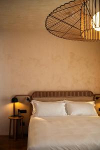a bedroom with a bed and a chandelier at Cala Ponte, a Tribute Portfolio Hotel in Polignano a Mare