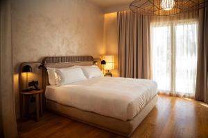 a bedroom with a large bed and a large window at Cala Ponte, a Tribute Portfolio Hotel in Polignano a Mare