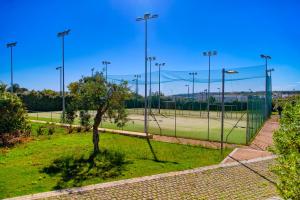 a tennis court with a tree on a tennis court at Cala Ponte, a Tribute Portfolio Hotel in Polignano a Mare