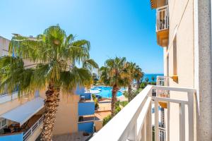 Una vista desde el balcón de un hotel con palmeras. en Casa del Sol Premium Cabo Roig, en Orihuela