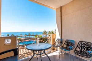 Un balcón con mesa y sillas y el mar. en Casa del Sol Premium Cabo Roig, en Orihuela