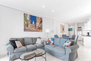 Una sala de estar con un sofá y dos mesas. en Casa del Sol Premium Cabo Roig, en Orihuela