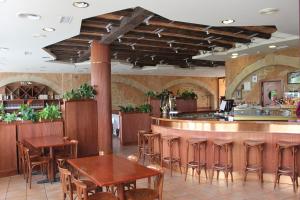 a restaurant with wooden tables and a bar at Hotel El Salt in Valderrobres