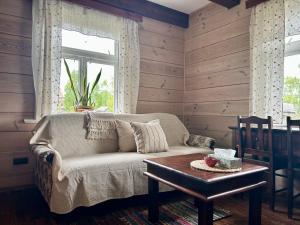 a living room with a couch and a table at Leśne PoBudki in Białowieża