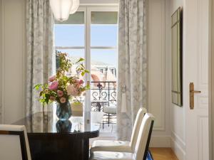 a dining room with a table and a vase of flowers at The Woodward - Auberge Resorts Collection in Geneva