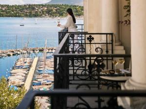 a woman standing on a balcony looking at the water at The Woodward - Auberge Resorts Collection in Geneva
