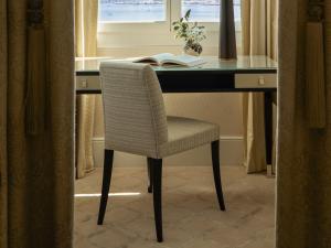 a desk with a chair in front of a window at The Woodward - Auberge Resorts Collection in Geneva