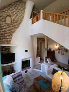 Una sala de estar con escalera y chimenea. en Le Petit Briacin, en Saint-Briac-sur-Mer