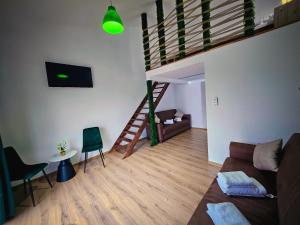 a living room with a couch and a staircase at One & Kos Resort in Costinesti