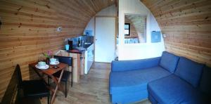 a living room with a blue couch and a table at Cosy Camping Suffolk in Ipswich