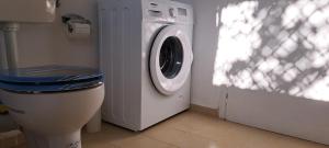 a washing machine in a bathroom with a toilet at Sweet Home Kini in Kinion