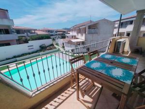 a balcony with a bench and a swimming pool at The pool house - Il Gabbiano in Palau