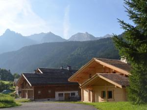 ein paar Gebäude mit Bergen im Hintergrund in der Unterkunft Chalet moderne 5 étoiles pour 10 pers. avec parking privé - FR-1-467-93 in Le Grand-Bornand