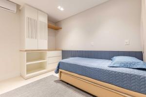 a bedroom with a blue bed and white cabinets at Apartamento alto padrão com piscina em Bombinhas in Bombinhas +19 photos
