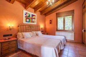 a bedroom with a large bed with orange walls at Ca la Montse in Viladrau +29 photos