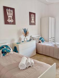una camera da letto con due letti con asciugamani sopra di Home Sisters a Trapani