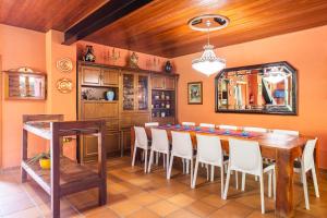 a dining room with a long table and white chairs at Ca la Montse in Viladrau