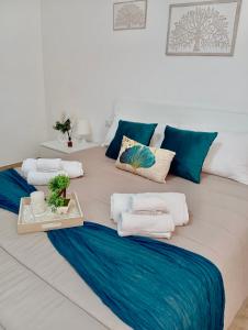 un grande letto con asciugamani blu e bianchi di Home Sisters a Trapani