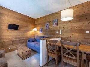 a living room with a blue couch and a table at Studio cabine 5 personnes avec balcon - La Plagne - FR-1-353-85 in Les Coches