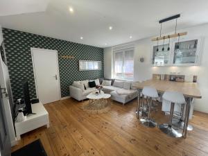 ein Wohnzimmer mit Sofa und Tisch in der Unterkunft Le Duplex Marquettois - 3 chambres in Saint-André