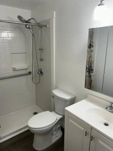 a white bathroom with a toilet and a shower at Hendrix Hospitality Suite in Pittsburgh