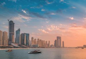 a boat in the water in front of a city at Happy ACADEMIA JBR in Dubai