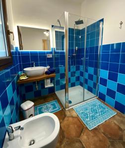 a blue tiled bathroom with a sink and a shower at Tenute Efis in Galtellì