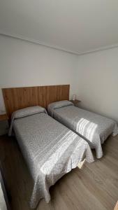 two beds sitting next to each other in a bedroom at vivienda turística Irún in Irún +13 photos