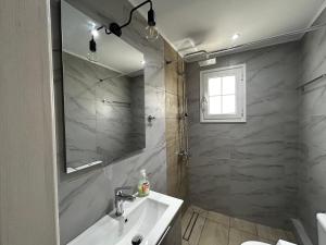 a bathroom with a sink and a mirror at Happiness Apartment 5 in Sidari