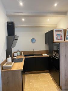 una cucina con lavello e fornello forno superiore di Maison moderne plain-pied 3 chambres jardin préau a La Rochelle Altre 16 foto